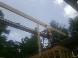 Carpenter setting a ridge beam over a new addition frame — Ice Dam Removal by Roofing Brothers in Northfork