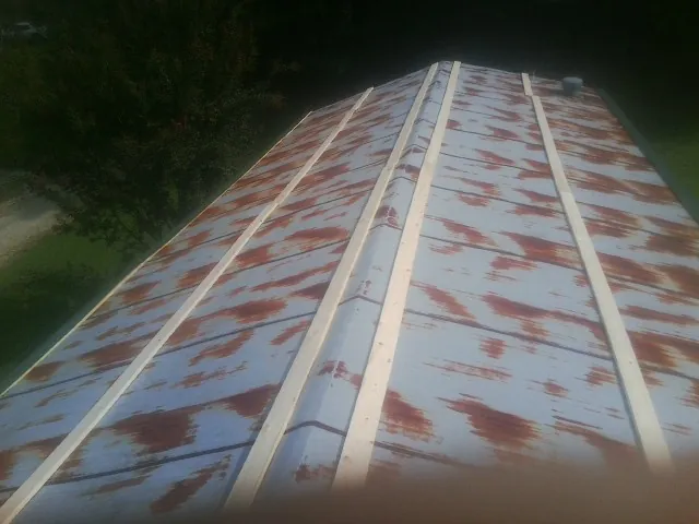 Rusted metal roof panels with new wood purlins before replacement — Storm Damage Roof Repair in Northfork by Roofing Brothers