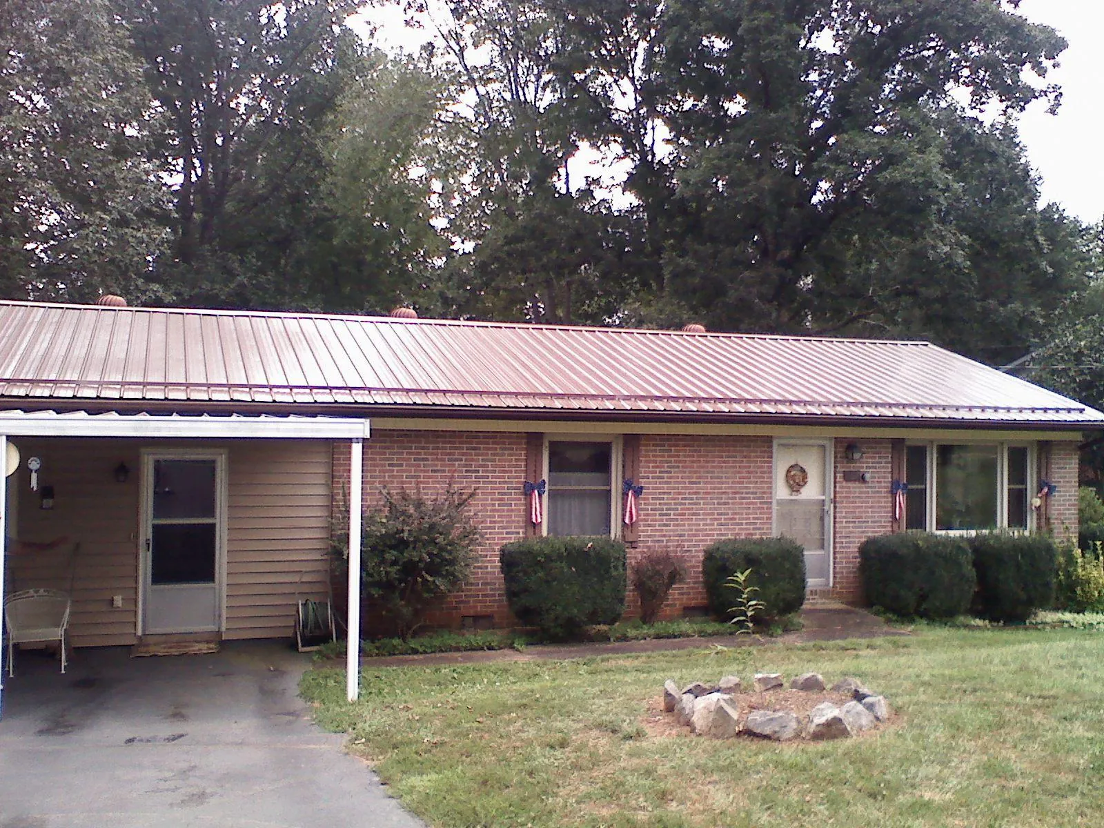 Bronze metal roof and carport on a brick ranch home in Northfork